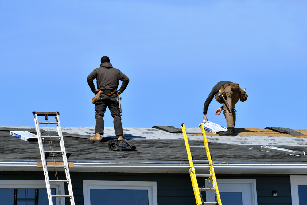 two workers working on spring roof repairs
